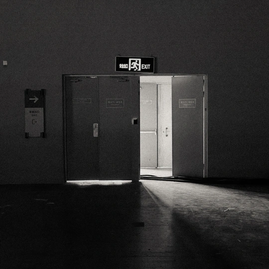 一个黑暗的房间 门是敞开的 墙上挂着一张告示。