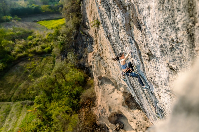 一个人正在爬一座陡峭的山崖