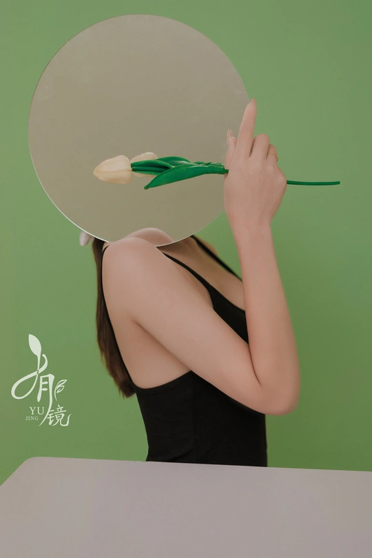 一位年轻女子手持剪刀 脸上有一面绿色和白色的镜子。