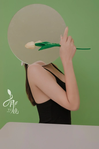 一位年轻女子手持剪刀 脸上有一面绿色和白色的镜子。