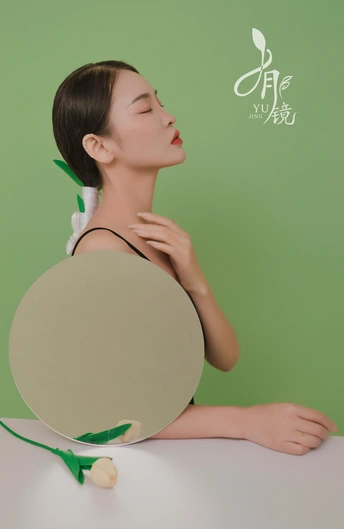 一位年轻女子举着一块白镜子照着她的脸