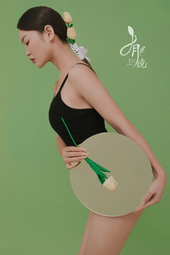 一位年轻女子拿着花在镜子前摆姿势