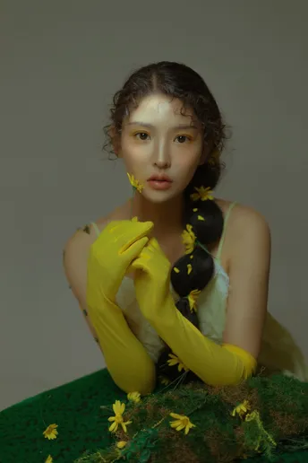 一位穿着绿色连衣裙 戴着黄色手套和花的女人