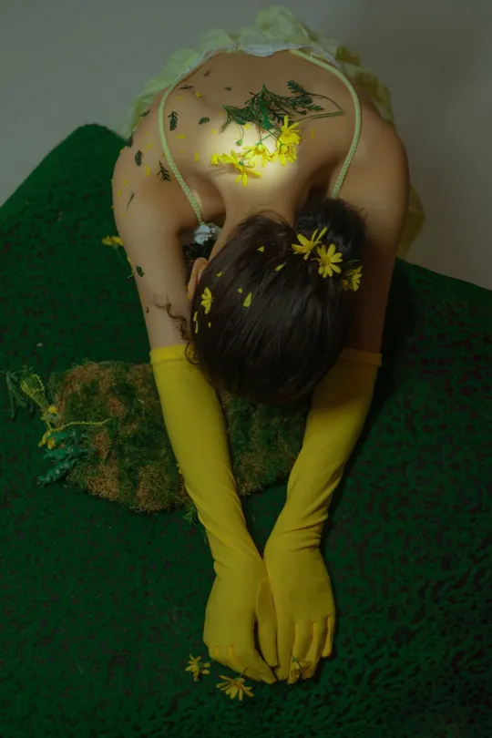 绿色草地上的一个蛋糕和带着黄色手套的女人