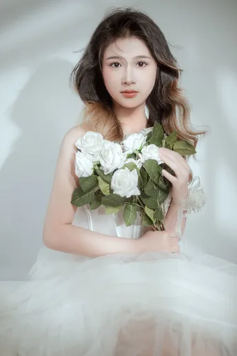 白裙少女手持白玫瑰花束的肖像