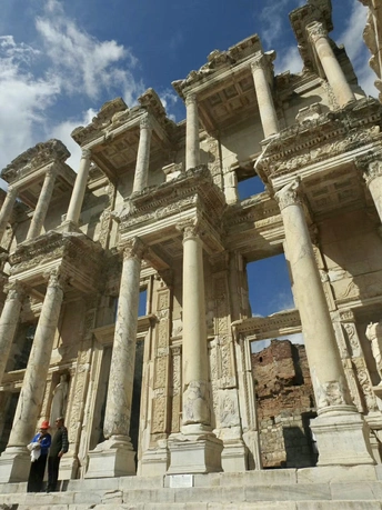 游客站在一座古代建筑的废墟前