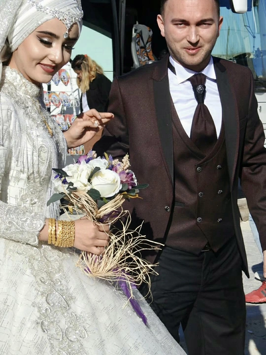 一位穿着传统婚礼礼服的男女手挽手一起走。