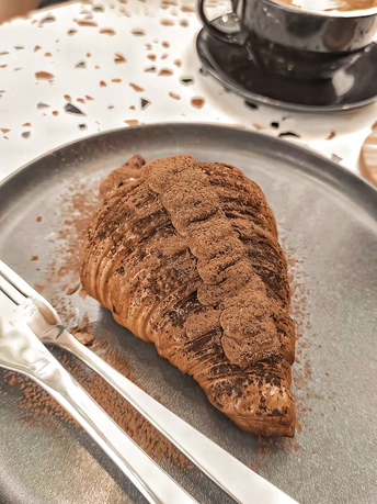 一个盘子 上面放着一块饼干 旁边放着一些咖啡