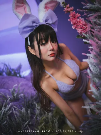 一位女士在紫花花田中与兔子一起摆姿势