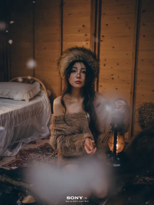一个穿着皮草的女人坐在一个带有床的房间里
