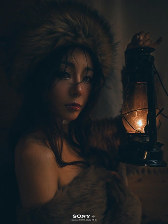 一位女性拿着灯笼 灯笼里有一支点燃的蜡烛
