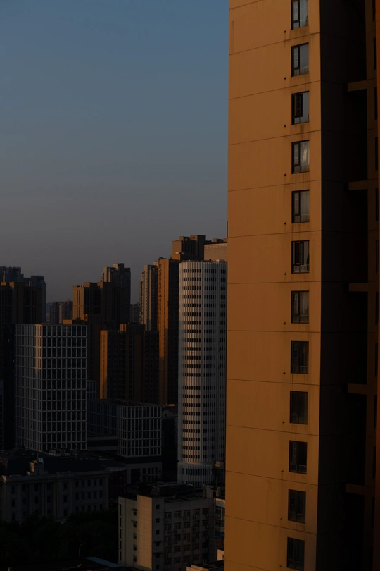 傍晚时分 满月在天空中升起 太阳在高层建筑后面落下。
