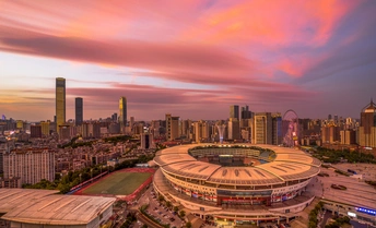 夕阳下的城市 前景中有天际线和体育场。