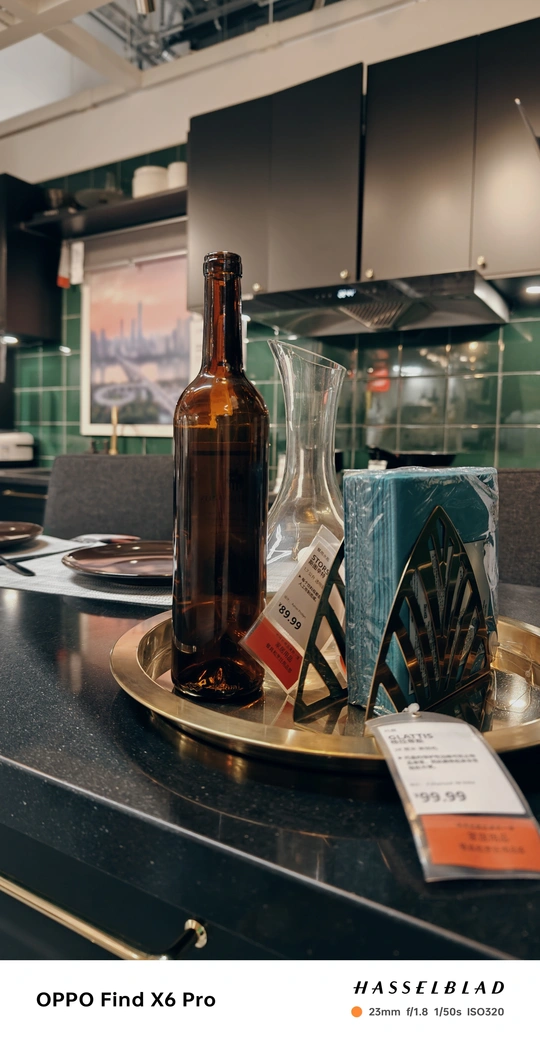 一瓶葡萄酒和一只玻璃杯放在厨房桌子上的托盘上。