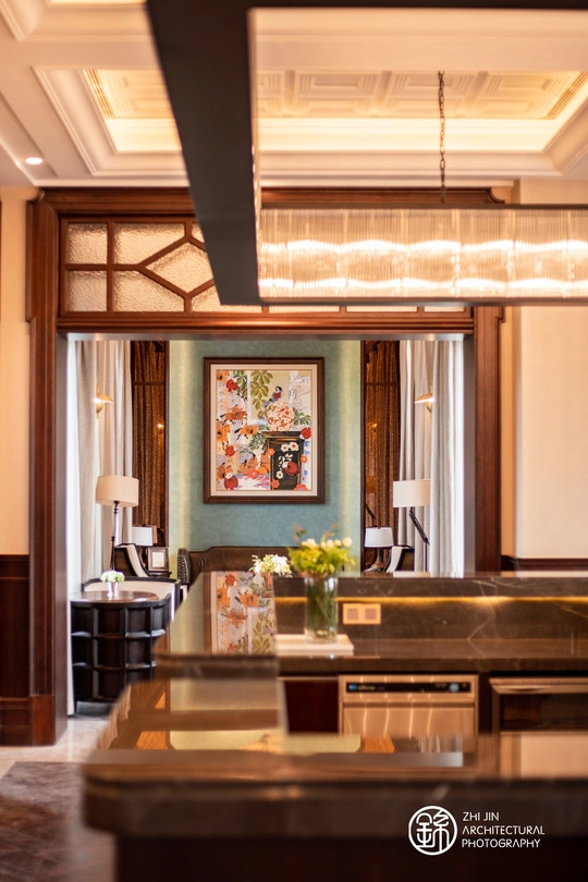 一个有大型画作、沙发、桌子、酒吧和其他家具的休息室。