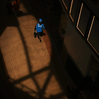 一个人穿着蓝色衬衫在黑暗的建筑物内奔跑