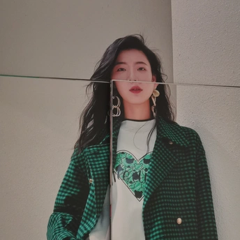 一位穿着绿色格子夹克和绿色西装的女孩