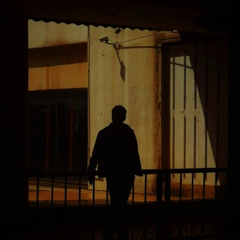 一个夜晚站在建筑物阴影中的男人的黑暗剪影