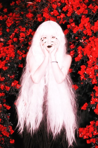 在红色花朵前的长发女人