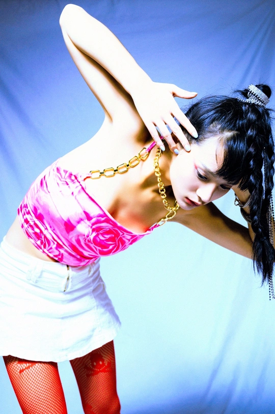 一位穿着粉色连衣裙 头发上挂着链子的年轻女子