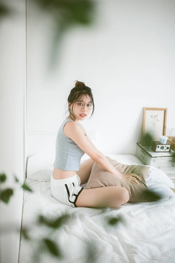 一个坐在白色床上的年轻女人