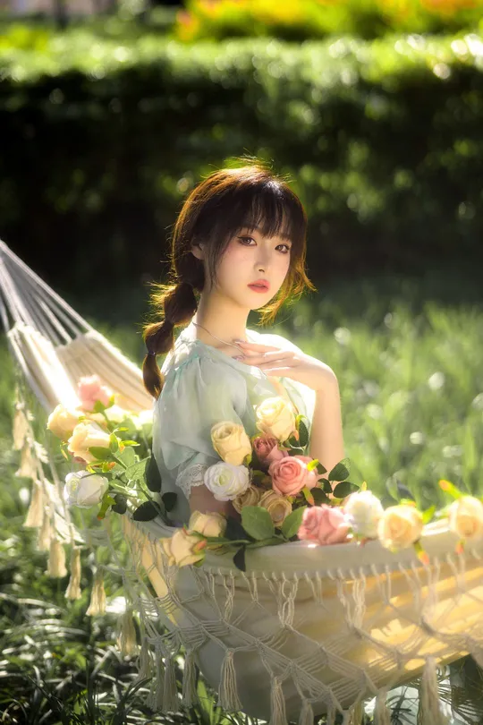 一个女孩坐在吊床上看花篮