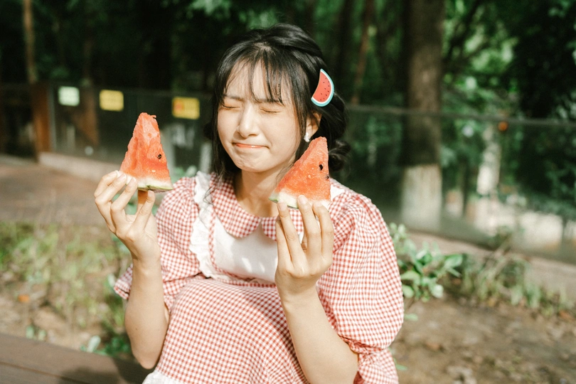 一位年轻女子手里拿着一颗小水melon