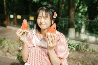 一位年轻女子手里拿着一颗小水melon