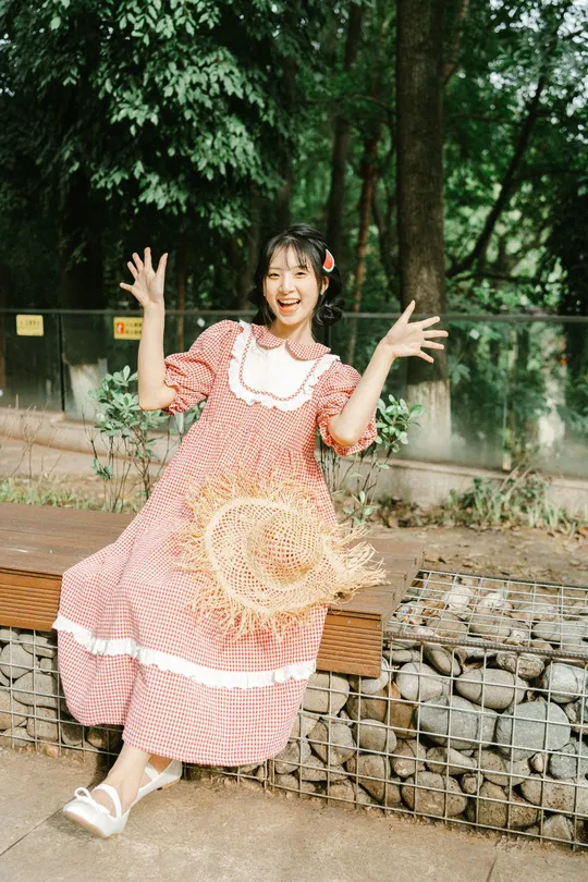 一个穿着粉红色裙子的年轻女子站在长凳旁边
