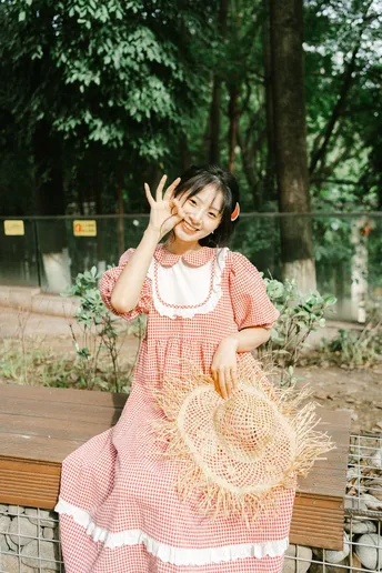 一个小女孩穿着粉红色裙子站在外面