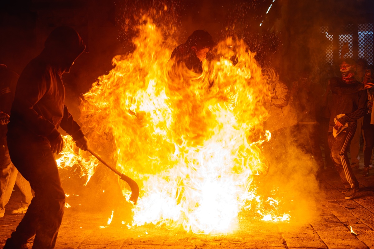 警察在抗议期间在街上设立了一个大火堆 火焰和烟花。