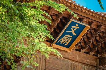 a blue sign hanging from the wall of an old buildi