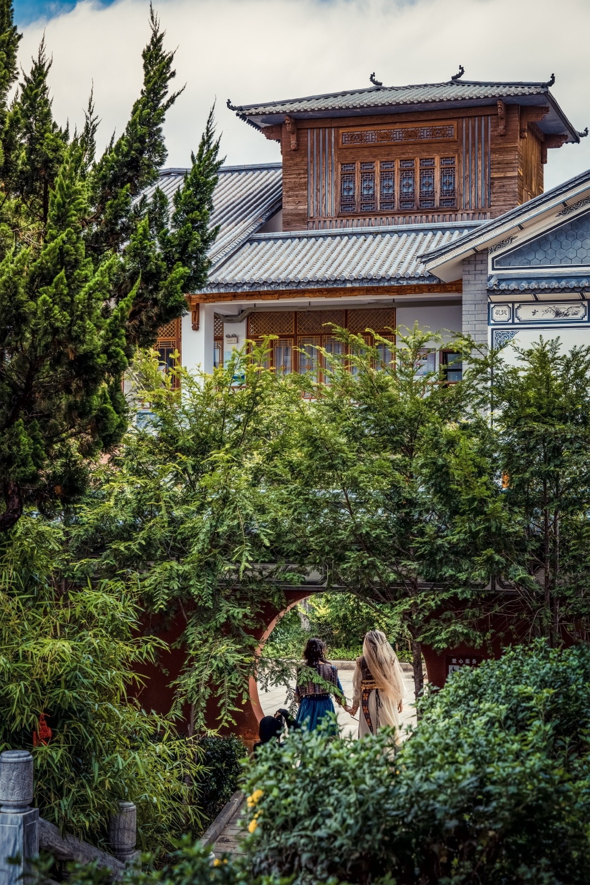 一些人在一个有宝塔背景的花园中穿过木桥