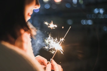 一个小女孩在晚上手里拿着一个点燃的火花