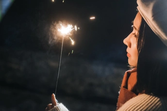 夜晚 一个年轻女孩手里拿着一颗发光的火花