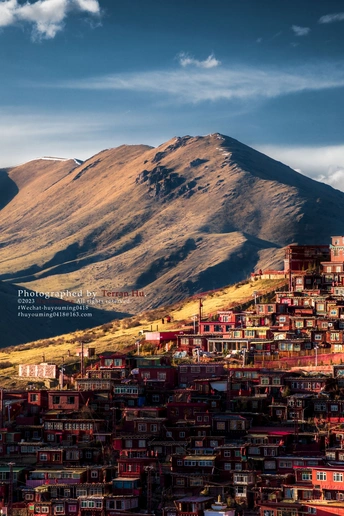 城市是位于山丘上的房屋群 背景是山脉。