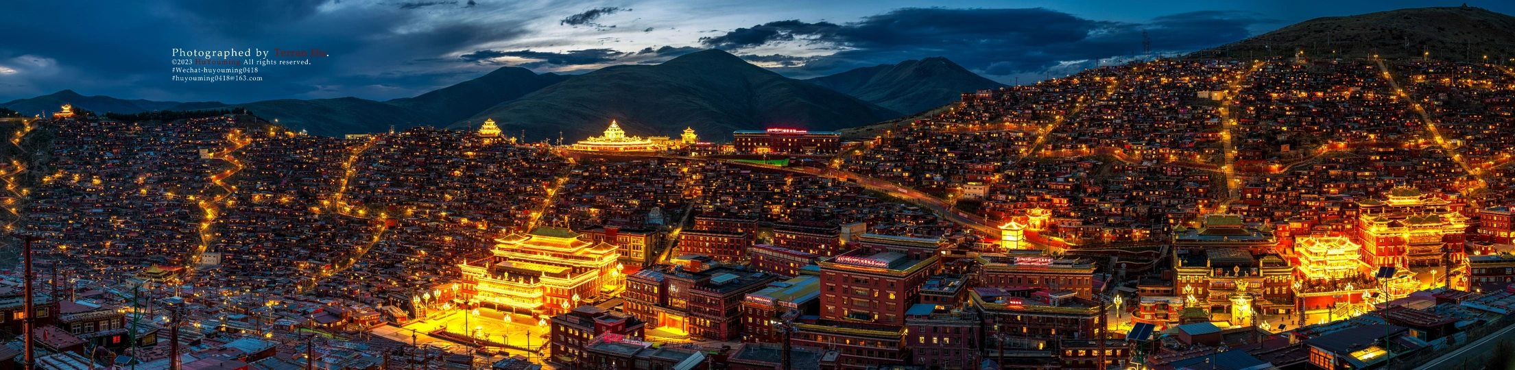 夜晚照亮的大型城市 背景是山脉。