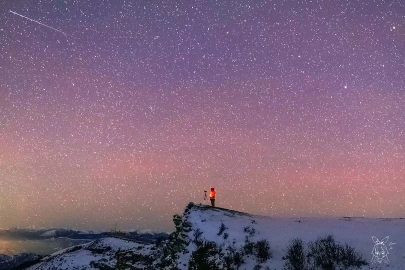 站在雪山上仰望夜空中的星星的人