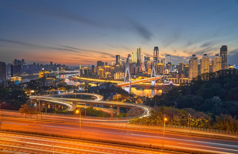 夕阳下或黄昏时城市天际线与高速公路上的交通