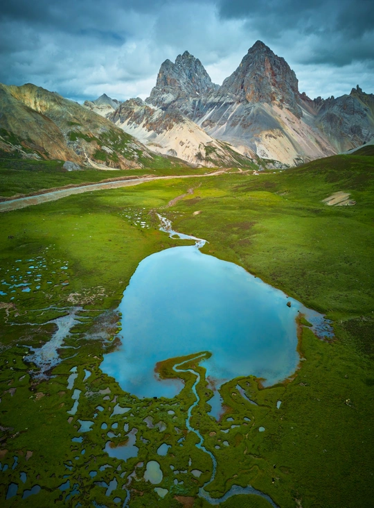 一片绿意盎然的山谷 蓝色的水 蓝色的天空下的一条河。