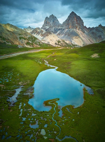 一片绿意盎然的山谷 蓝色的水 蓝色的天空下的一条河。