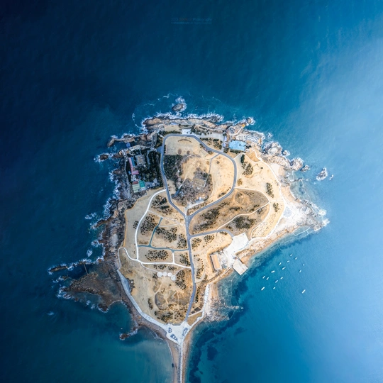 一个小岛被蓝色海水环绕的 aerial