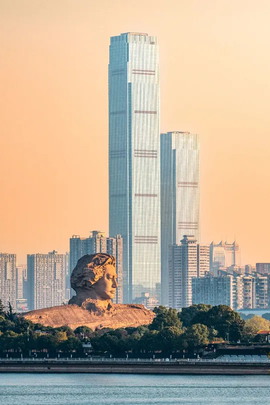 城市前方有一大片水域 周围有高大的建筑和摩天大楼。