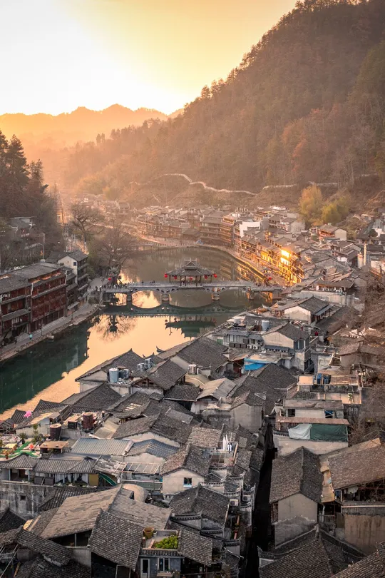夕阳下俯瞰河流和山峦的小村庄