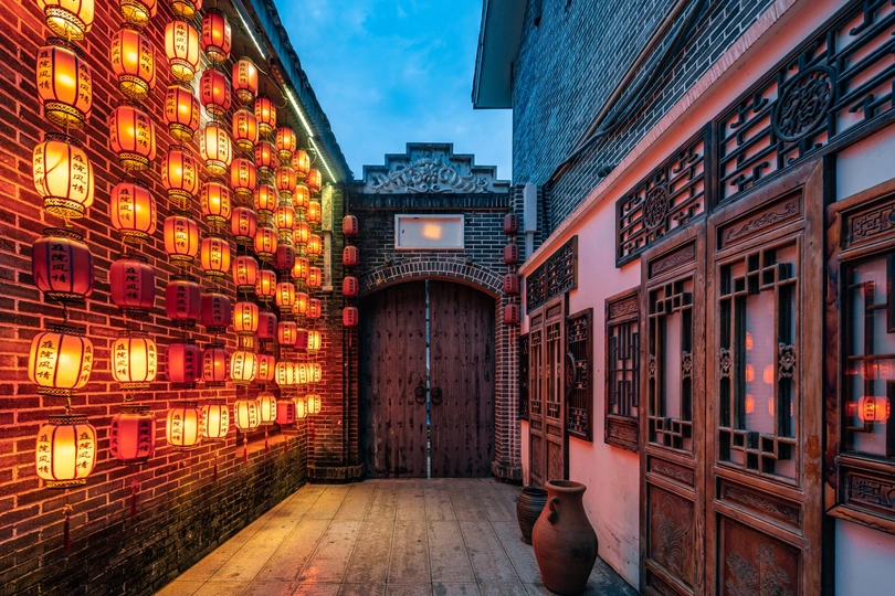 夜晚的老城区里的一个巷子 被墙上的灯笼照亮了。