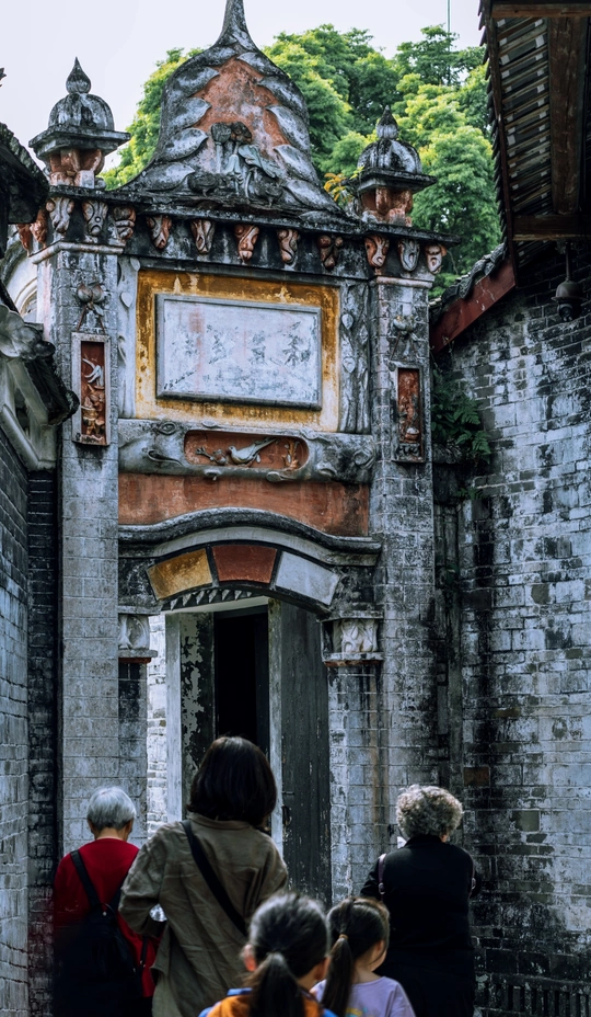 沿着一座老建筑旁边的一条小街道行走的人群