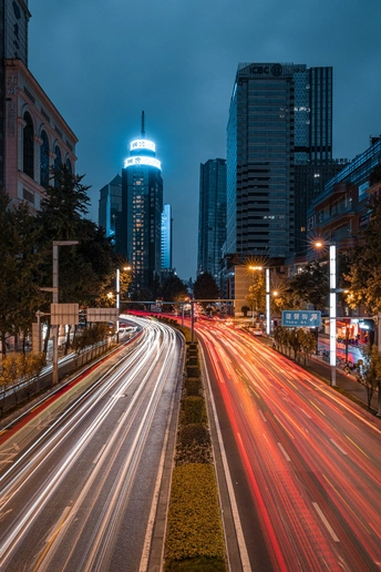 夜晚的城市街道 有汽车和路灯在道路上 还有高楼大厦。
