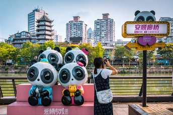 一位女士在城市的 bench 前拍照 bench 上堆满了毛绒玩具