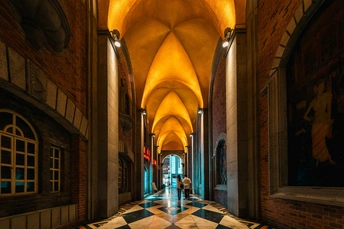 教堂内部的一个走廊 有柱子和拱门 以及铺有瓷砖的地面。