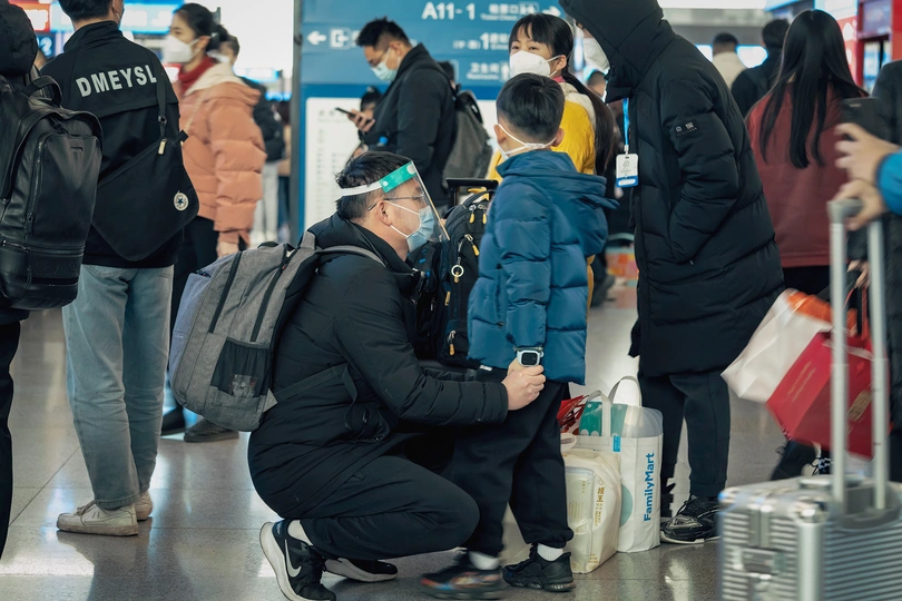 一群戴口罩的人在机场站着